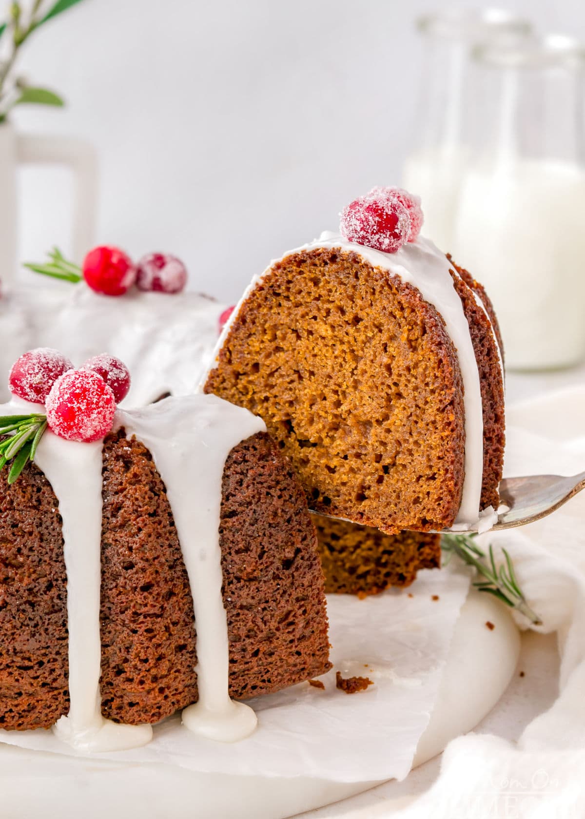 A spatula holding a piece of gingerbread bundt cake above the rest of the cake.