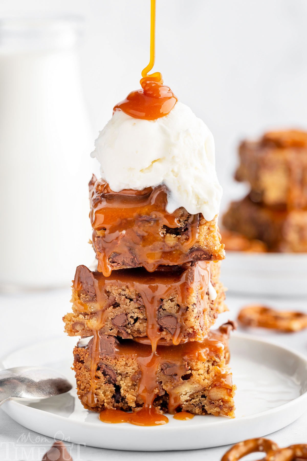 A stack of blondies with a scoop of vanilla ice cream and salted caramel sauce drizzled on top.