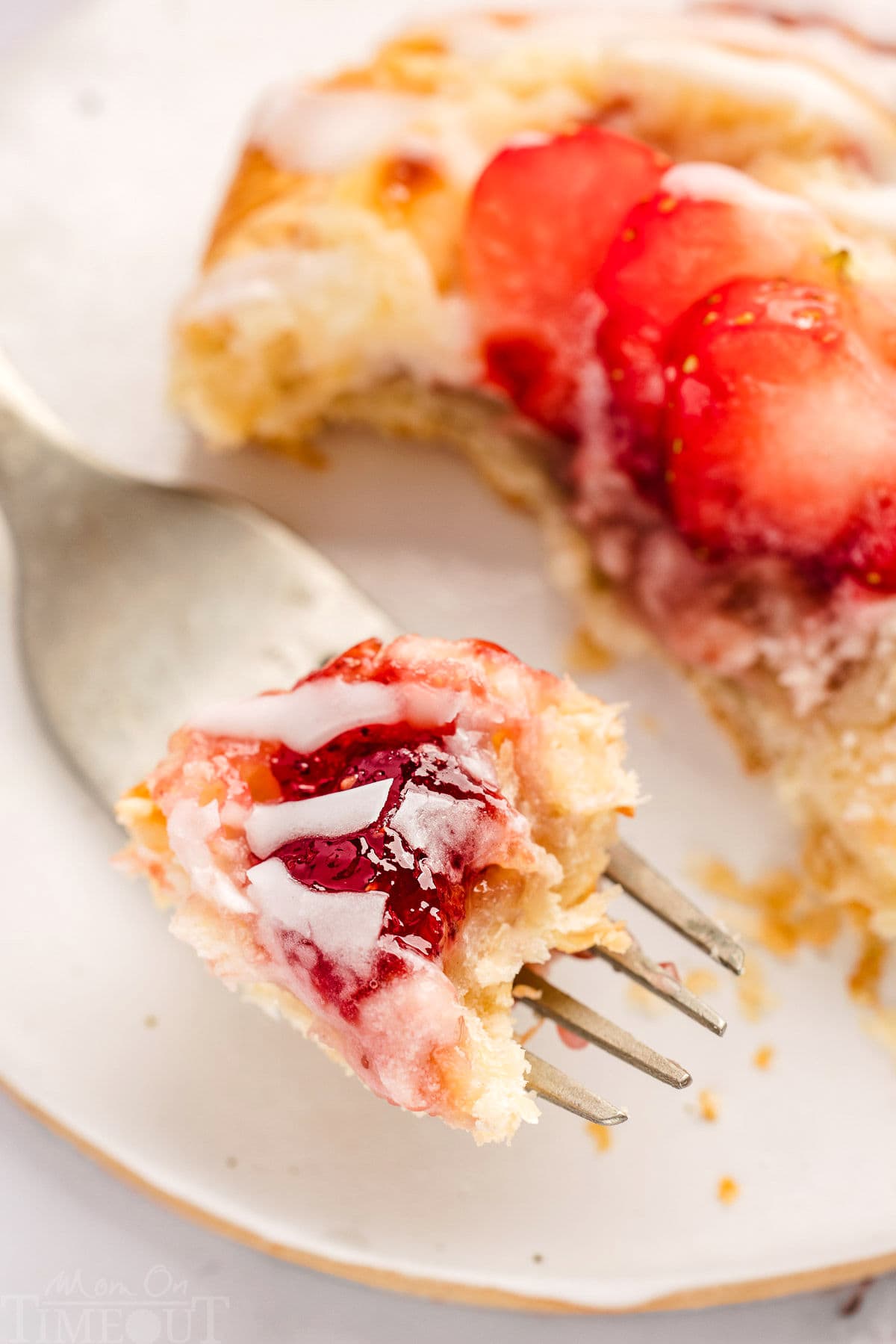 Strawberry Danish on plate with forkful of danish.