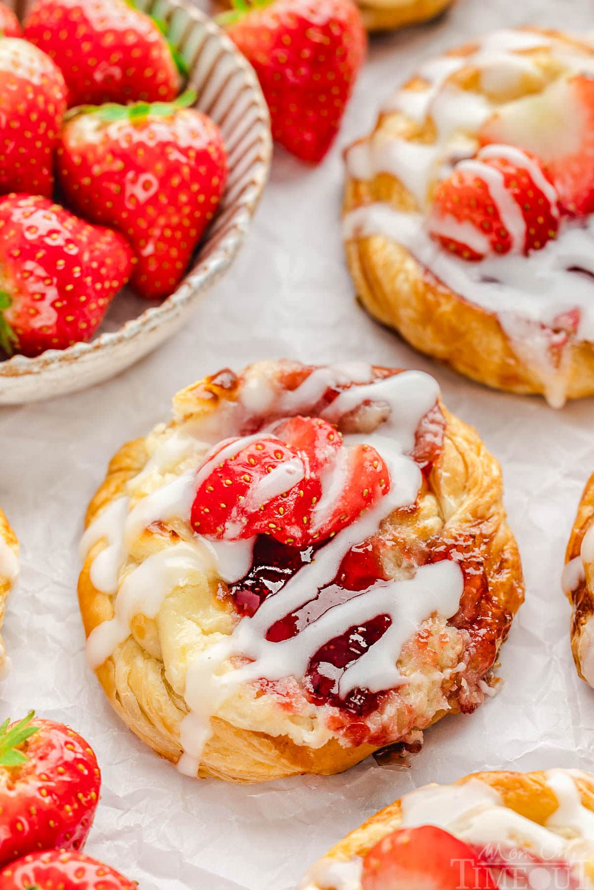 Strawberry danish with cream cheese topped with a glaze and fresh strawberries.