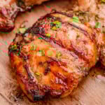 Grilled balsamic chicken marinated in balsamic chicken marinade sitting on wood board.