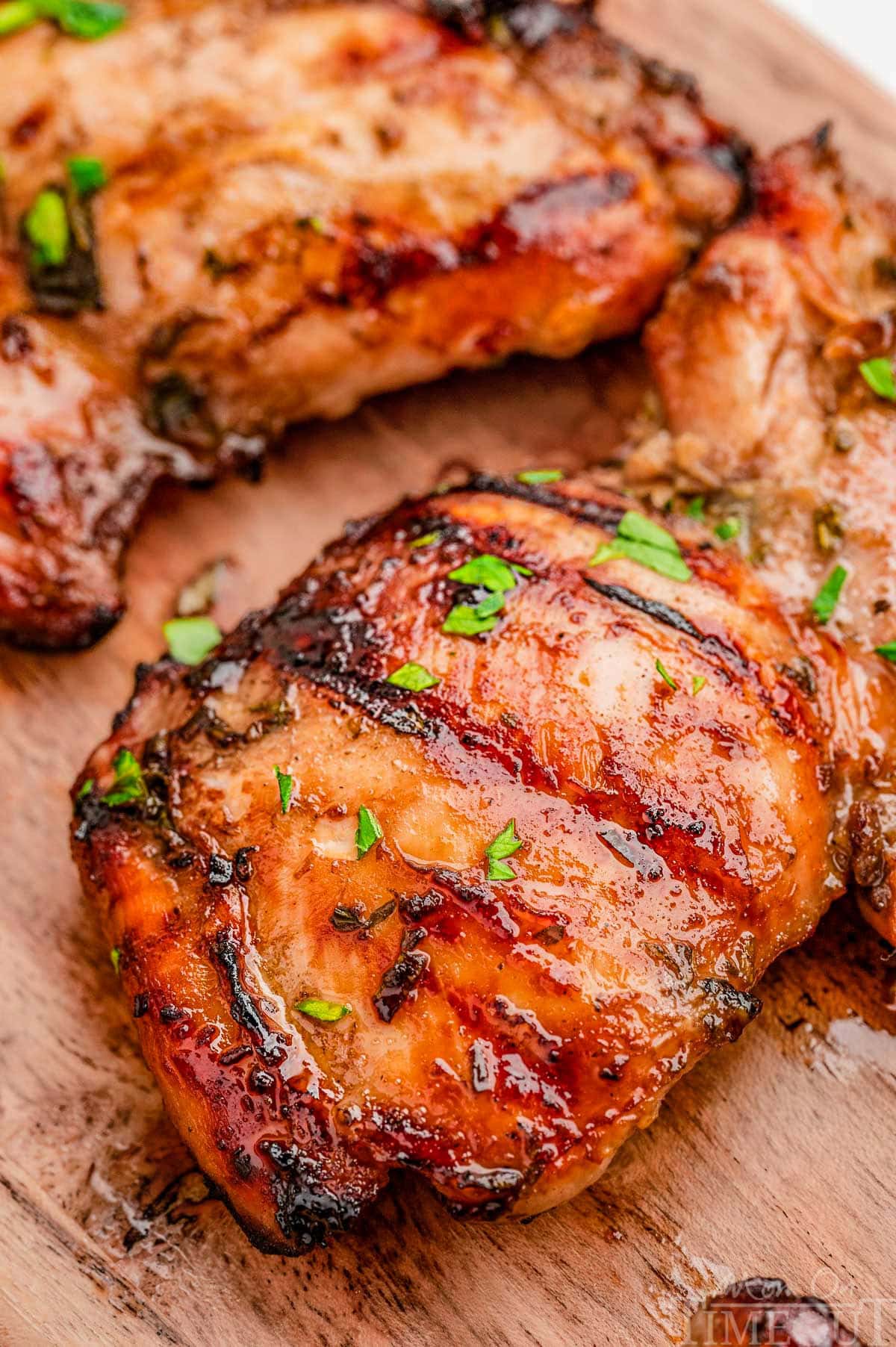Grilled balsamic chicken marinated in balsamic chicken marinade sitting on wood board.