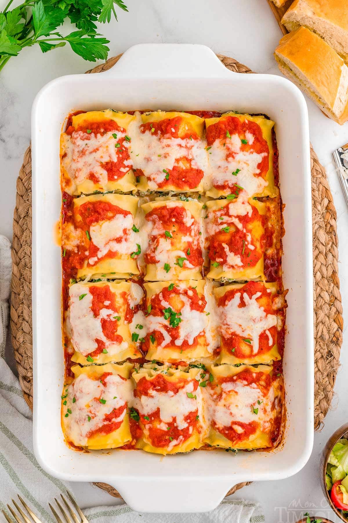Top down shot of lasagna roll ups in a white casserole dish baked and ready to be served.
