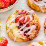 Close up of Strawberry danish with cream cheese topped with a glaze and fresh strawberries.