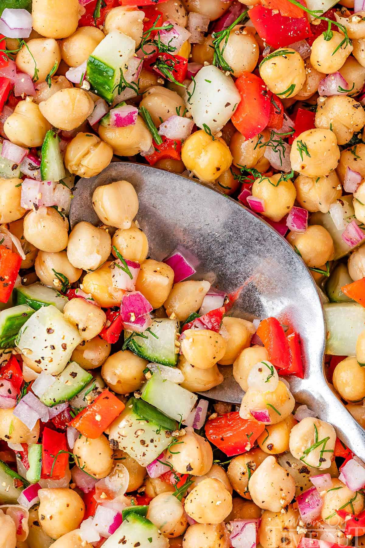 Overhead look at a closeup of a garbanzo salad in a large white bowl.