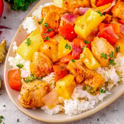 Close up look at Hawaiian Chicken recipe plated with rice on an oval plate.