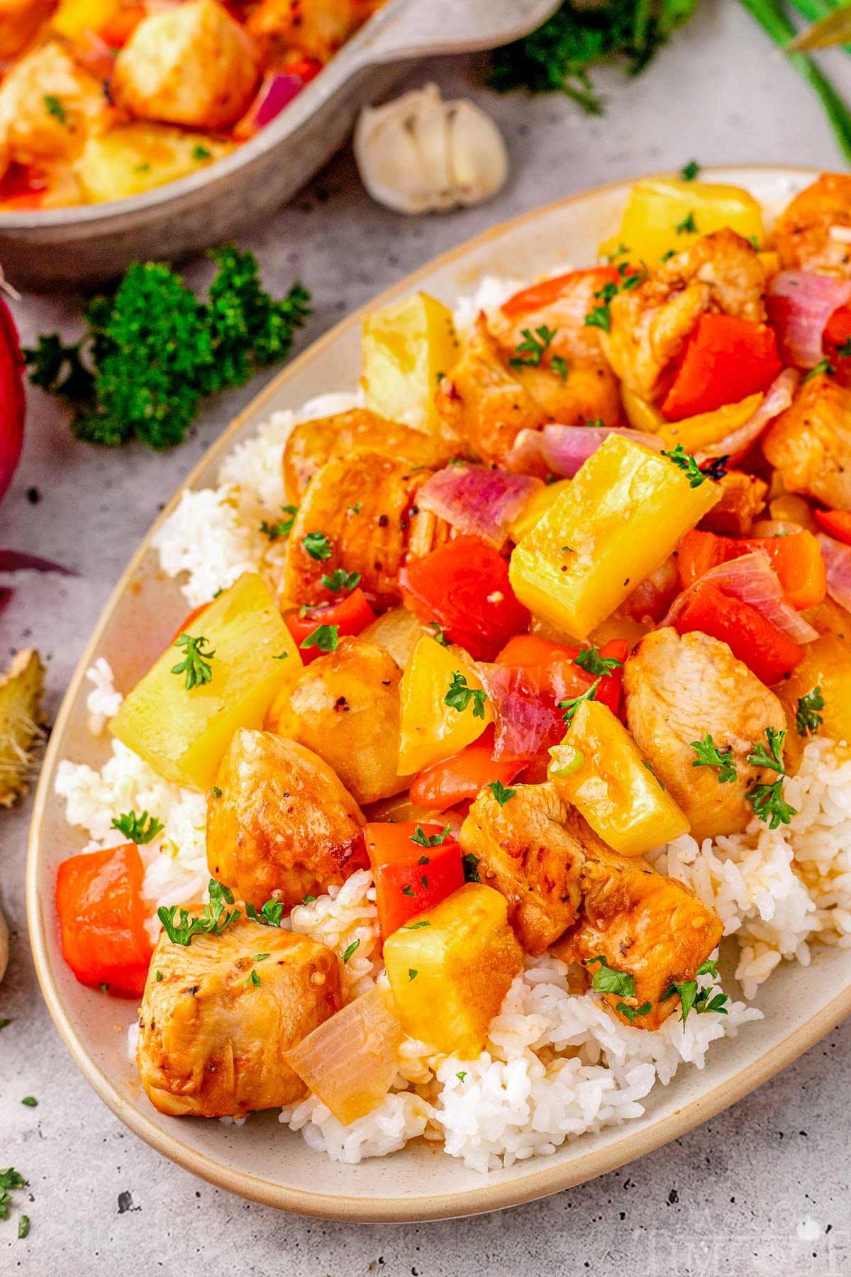 Close up look at Hawaiian Chicken recipe plated with rice on an oval plate.