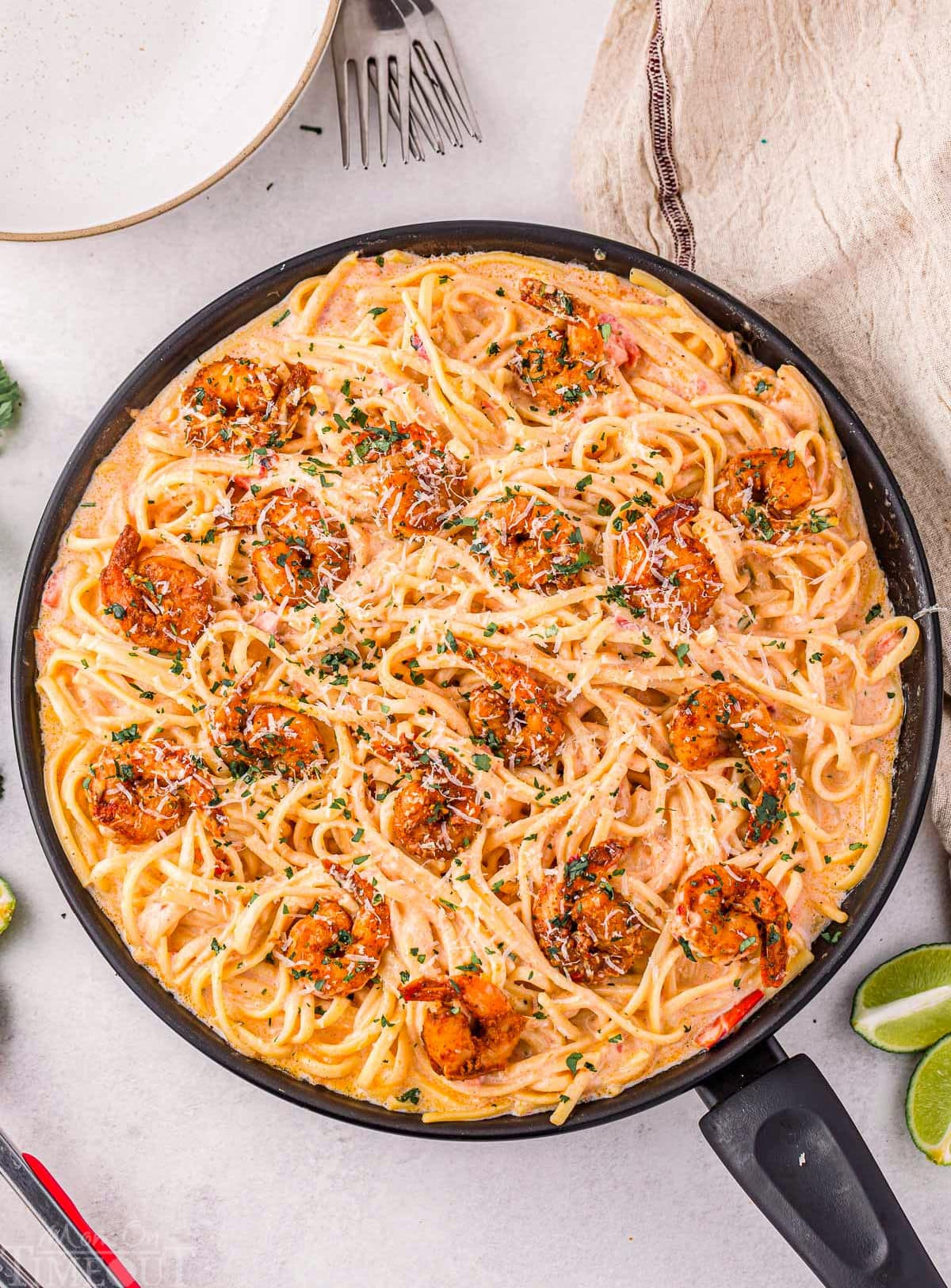 Overhead shot of cajun shrimp pasta recipe still in skillet garnished and ready to serve.