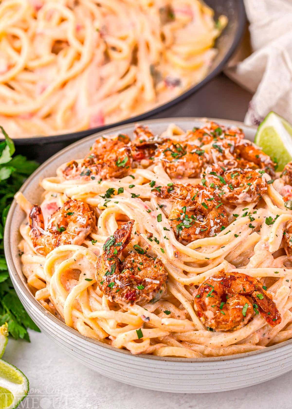Close up look at bowl of cajun shrimp pasta recipe with a rich Parmesan cream sauce and topped with spicy crispy Cajun shrimp.
