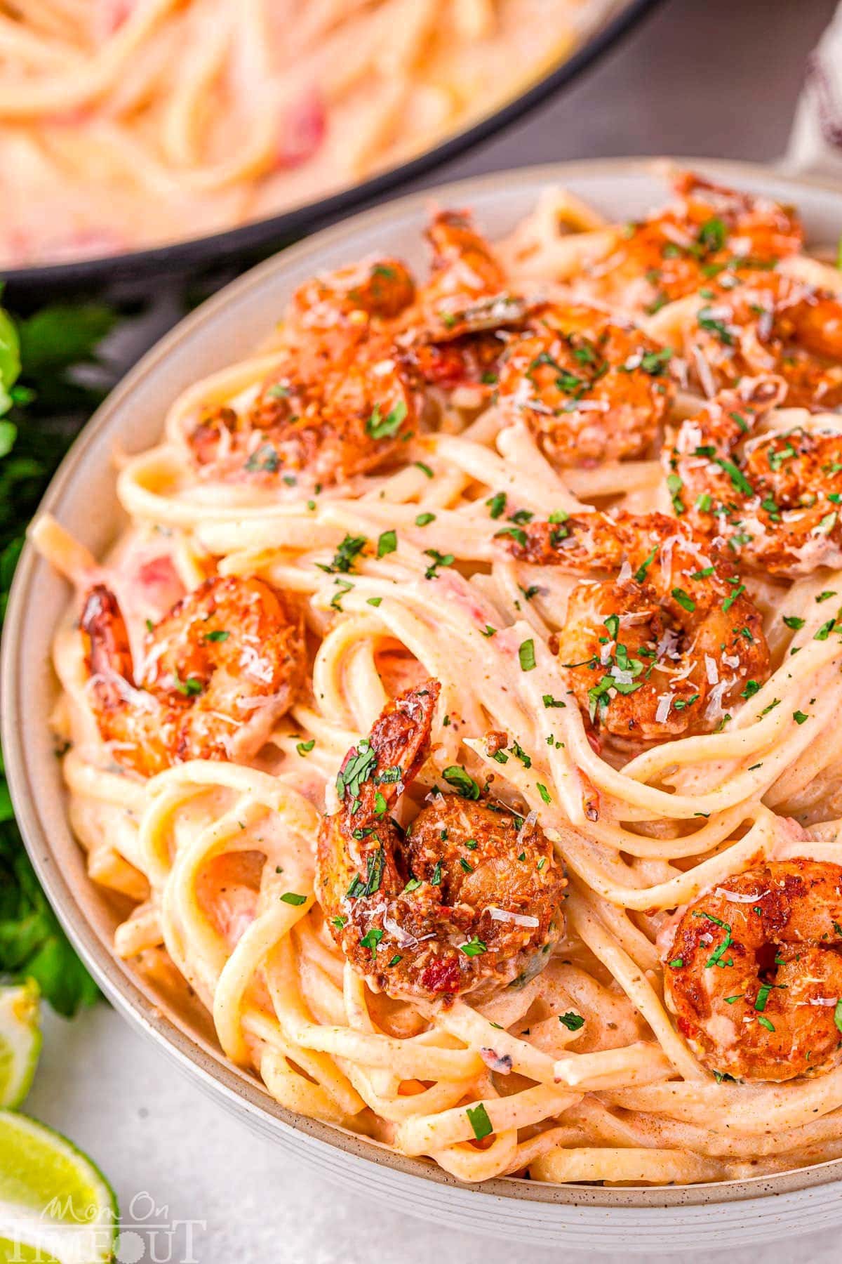 close up look at bowl of cajun shrimp pasta with a rich Parmesan cream sauce and topped with spicy shrimp.