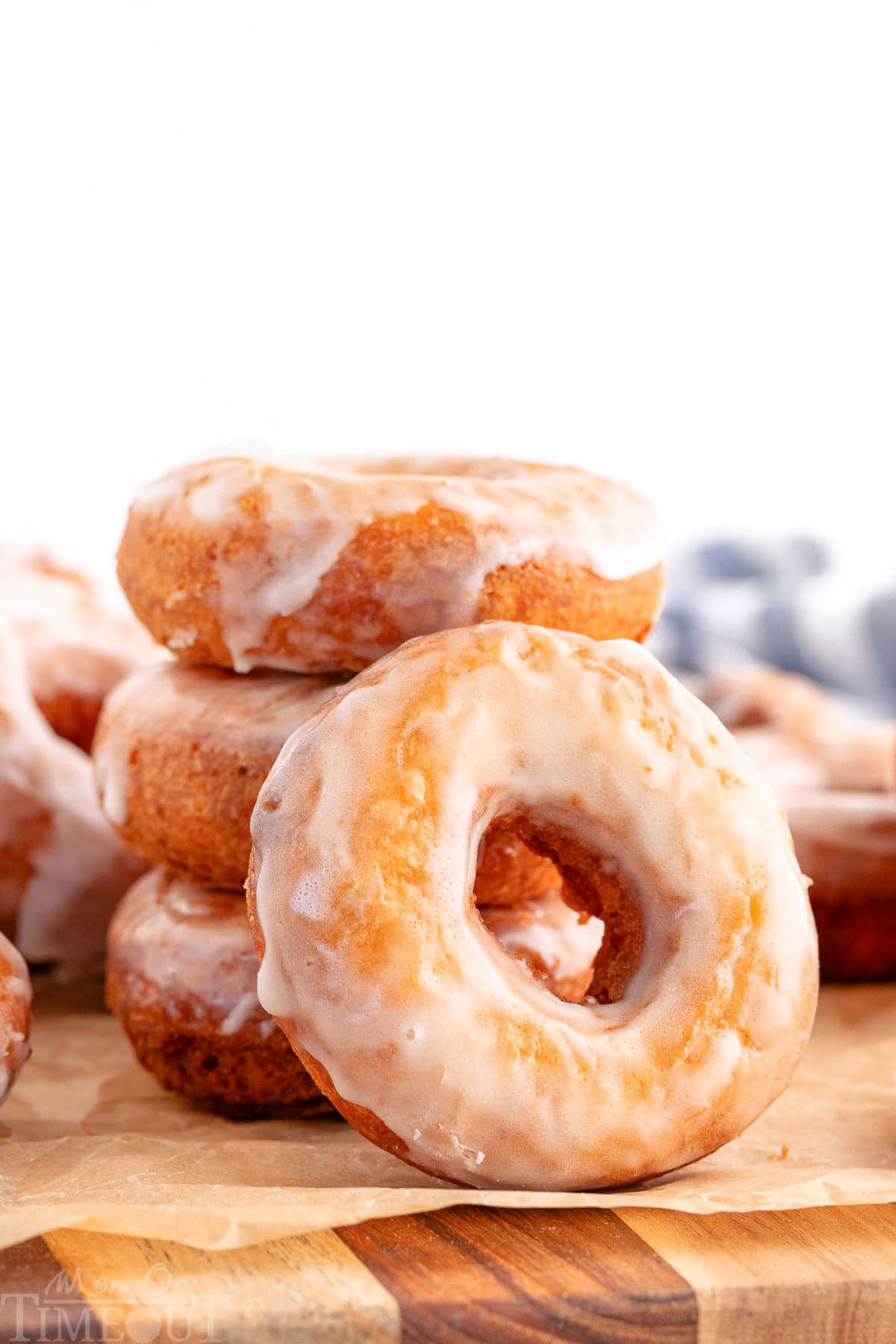 Donuts stacked three high with one glazed cake donut leaning against the stack.