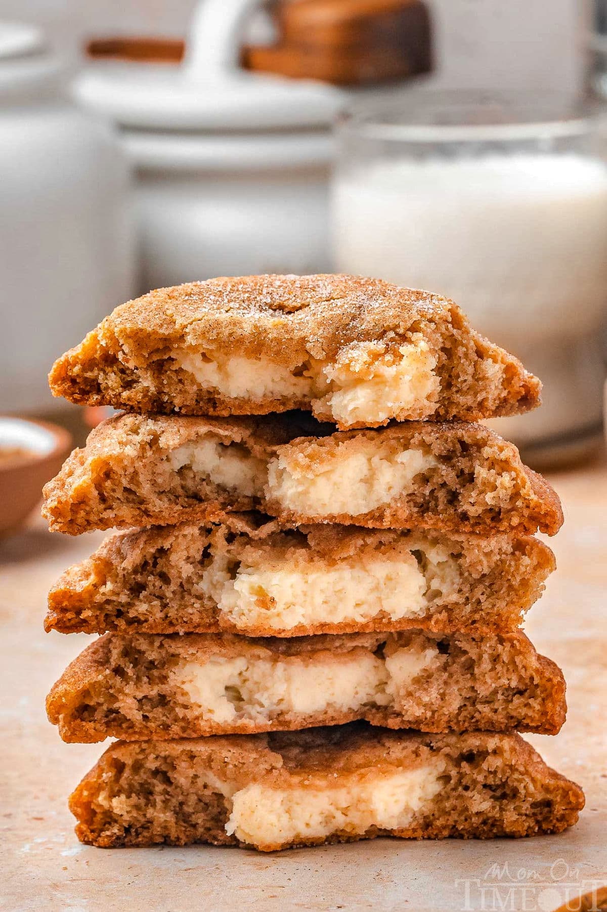Five churro cheesecake cookies stacked, all cut in half with the cheesecake center showing.