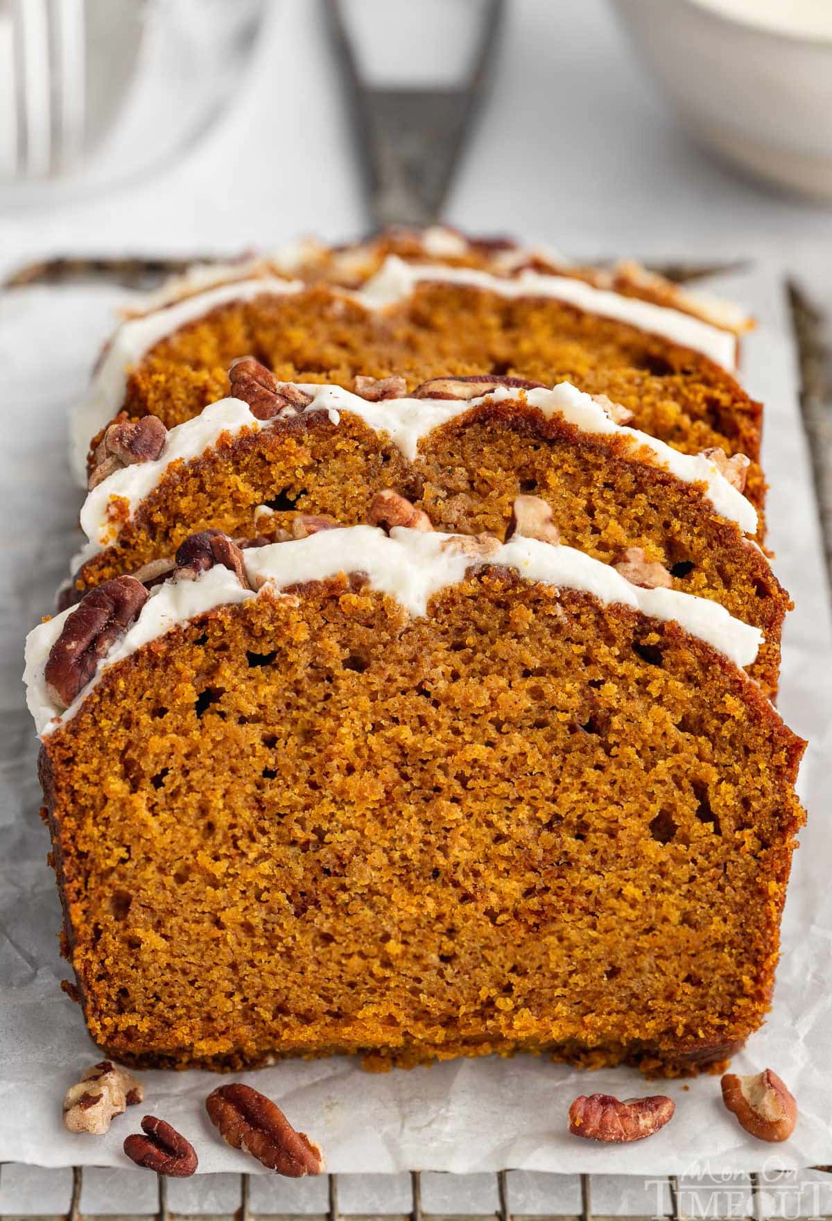Three slices cut from pumpkin loaf recipe sitting on board.