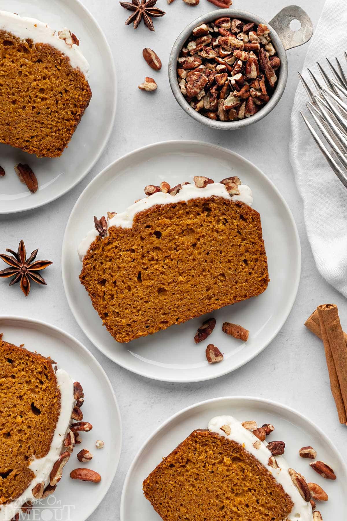 Overhead shot of recipe for pumpkin bread cut into slices and plated. Four plates shown.