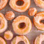 Overhead shot of sour cream cake donut on wire rack topped with glaze.