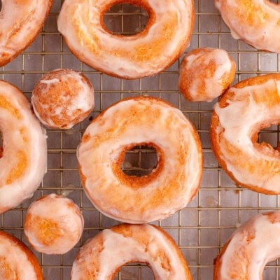 Overhead shot of sour cream cake donut on wire rack topped with glaze.