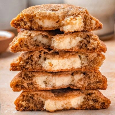 Five churro cheesecake cookies stacked, all cut in half with the cheesecake center showing.