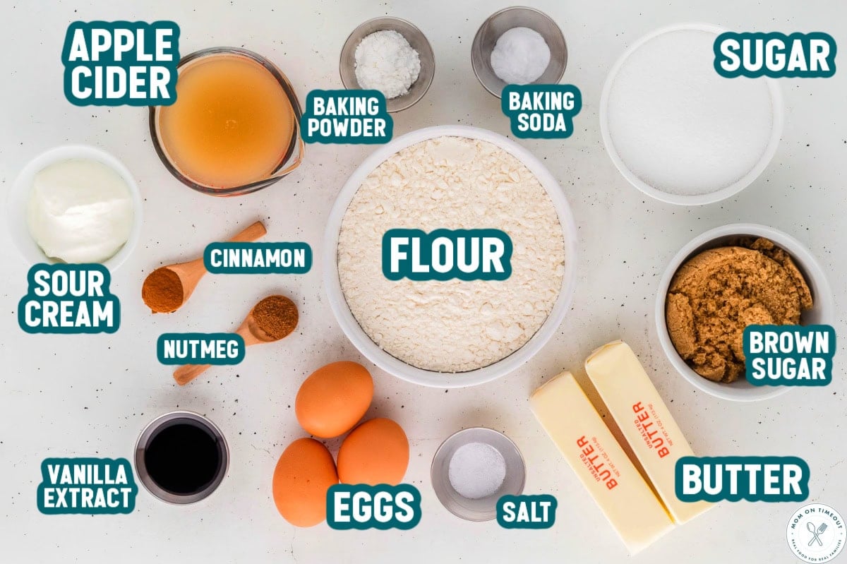 Overhead shot of apple cider donut cake ingredients measured out into small bowls ready to be used in the recipe. Ingredients are labeled.