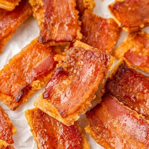 Bacon crackers on white parchment made with club crackers, bacon and brown sugar.