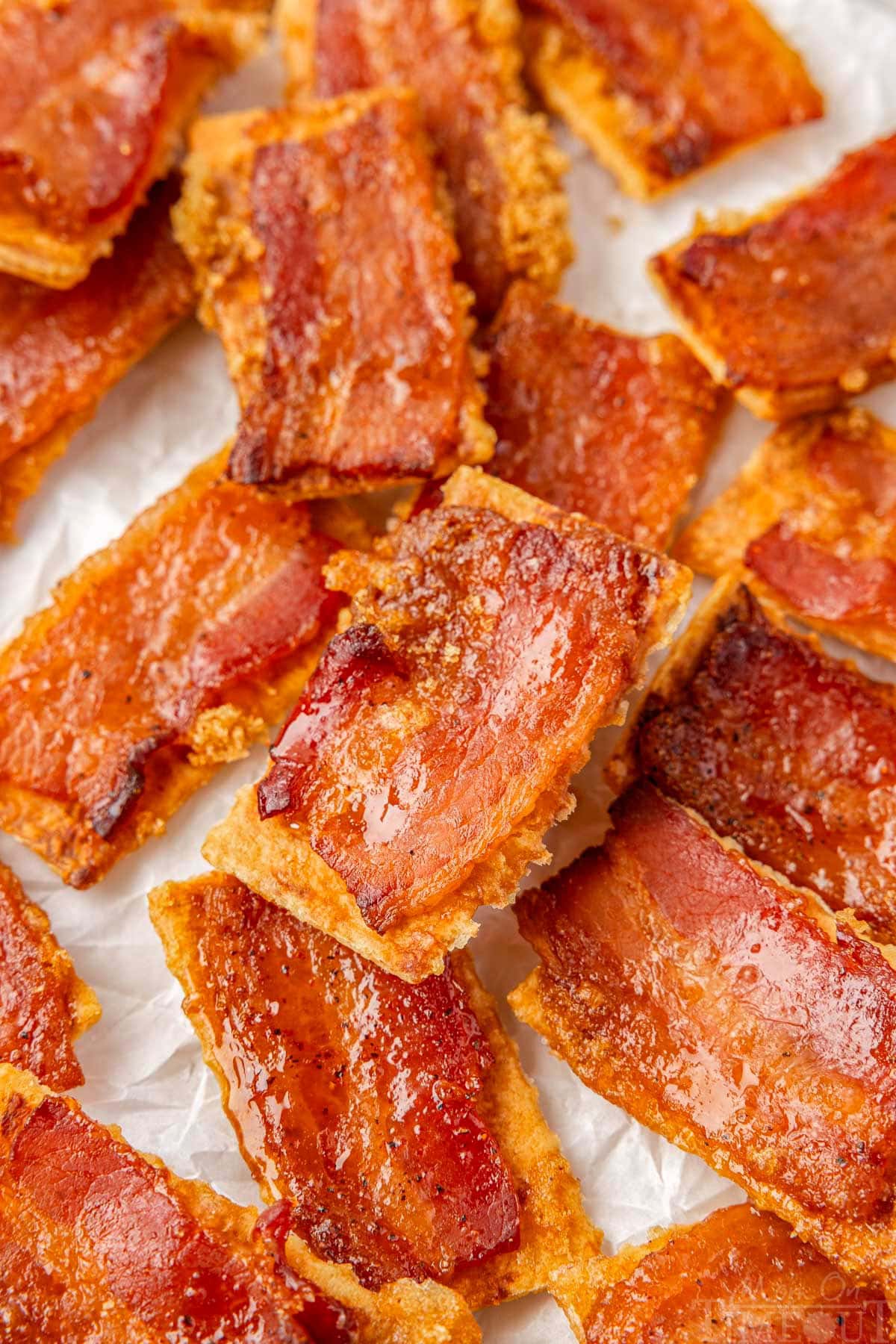 Bacon crackers on white parchment made with club crackers, bacon and brown sugar.