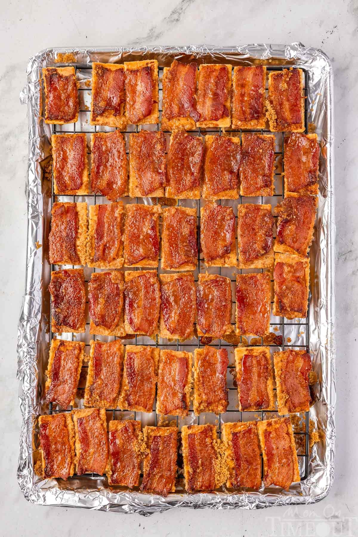 Overhead shot of candied bacon crackers on baking sheet with cooling rack in it.