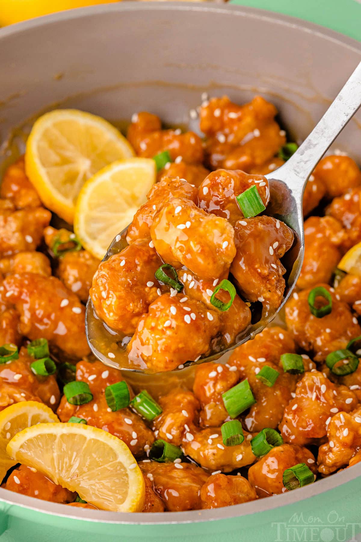 Lemon chicken chinese being served from skillet.