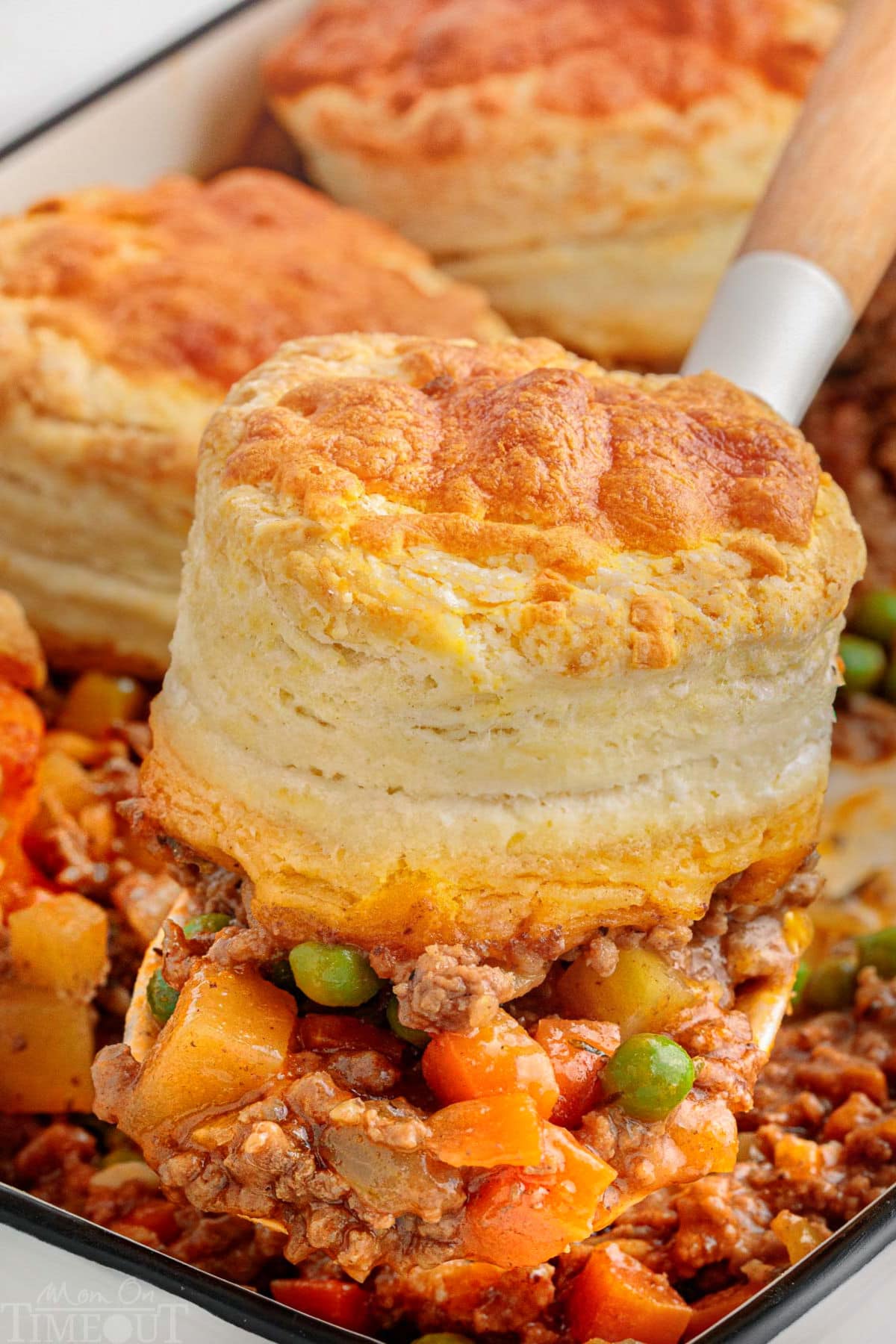 Spatula pulling out a serving of this recipe for beef pot pie out of the casserole dish.