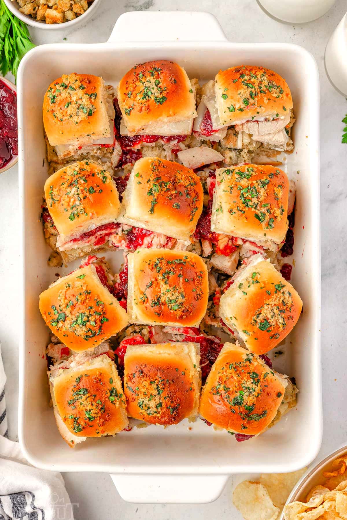 Overhead shot of 12 turkey sliders in a white baking dish ready to be enjoyed.