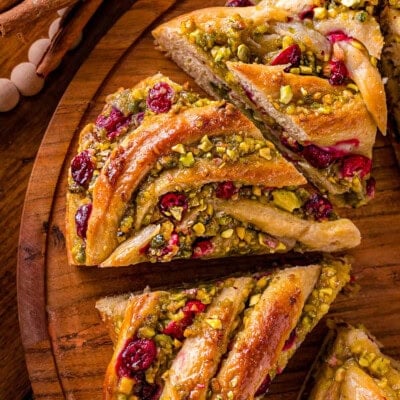 Four pieces of babka bread wreath cut up on a round board.