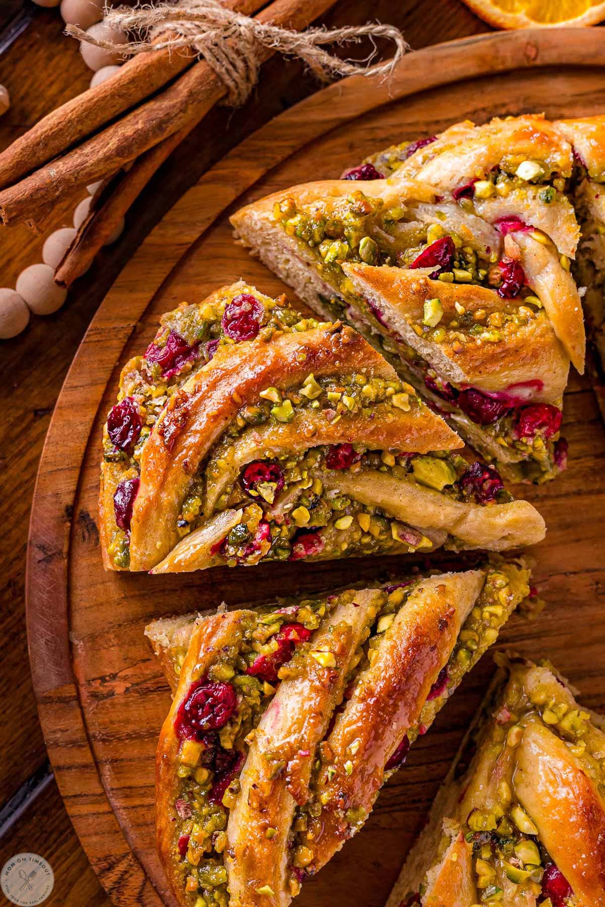 Four pieces of babka bread wreath cut up on a round board.
