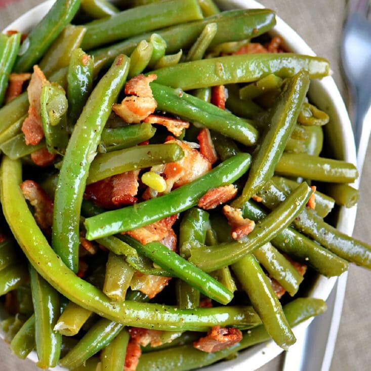 Overhead shot of green beans with bacon in bowl ready to serve.