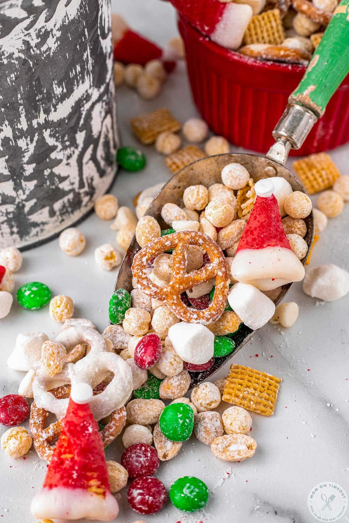 Vintage scoop with green handle and a serving of santas christmas snack mix in it.