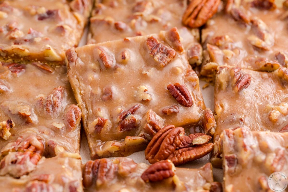 Wide shot of pieces of pecan pie bark in a baking sheet. The bark is cut into squares.