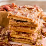 Tall stack of pecan pie bark recipe with graham crackers. More pieces scattered around the stack.