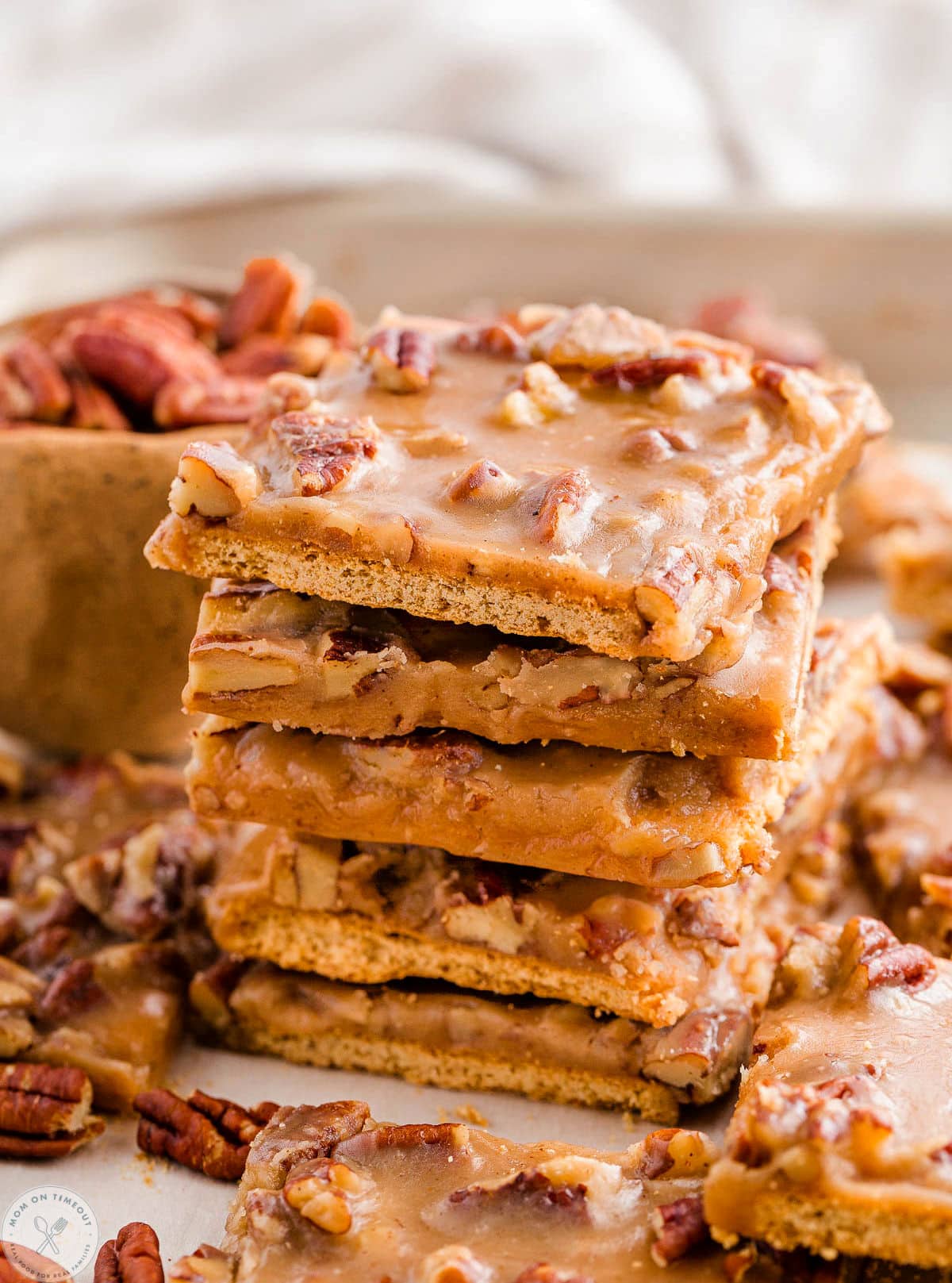 Tall stack of pecan pie bark recipe with graham crackers. More pieces scattered around the stack.