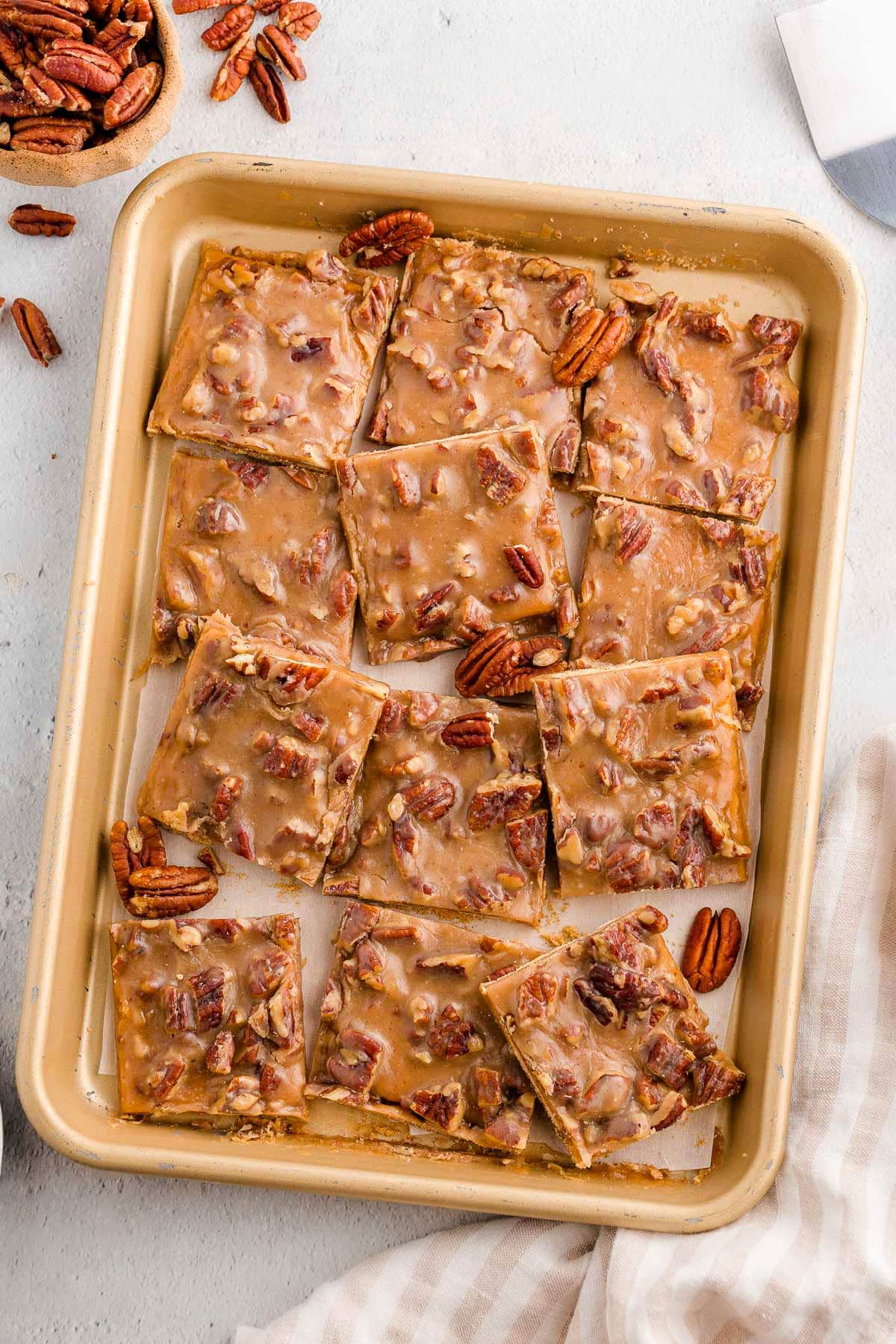 Overhead shot of quarter sheet pan filled with pieces of pecan pie bark.