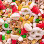 Close up shot of santa hat christmas snack mix including cereal, pretzels and candy.