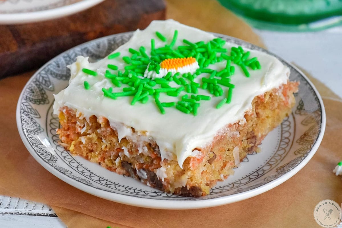 Whole piece of carrot cake bar on white round plate.