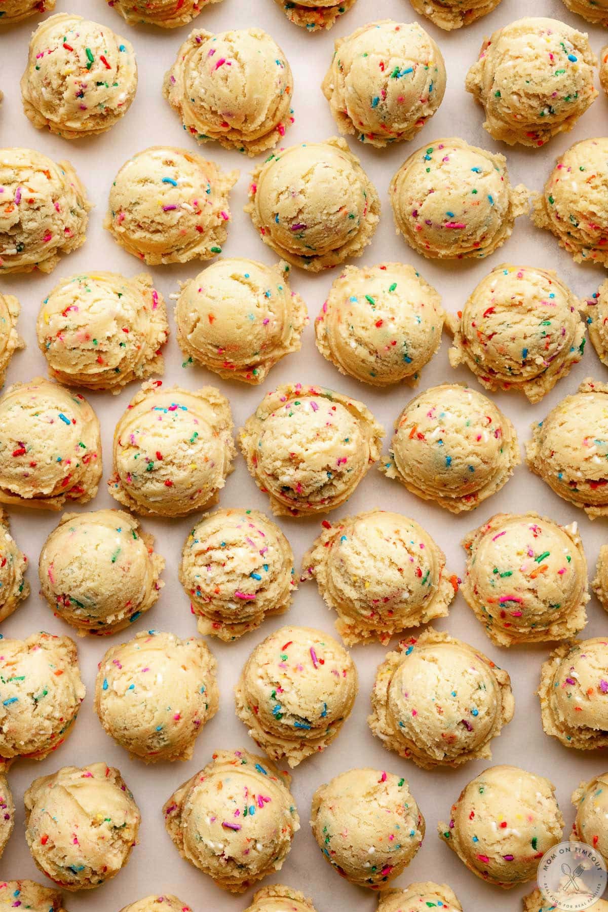 Overhead shot of funfetti cookie dough balls on baking sheet ready to be baked.