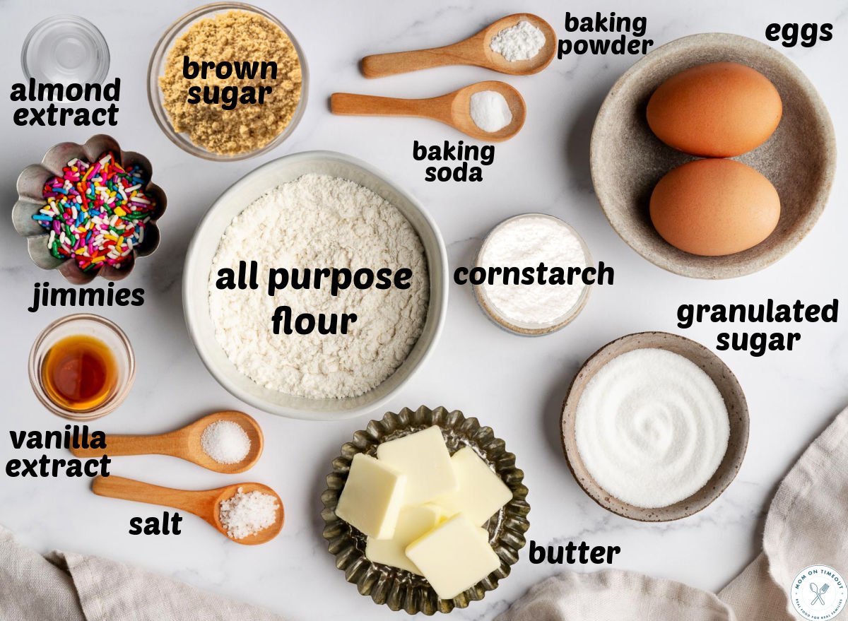 Overhead shot of sprinkle cookie ingredients measured into small bowls and labeled.
