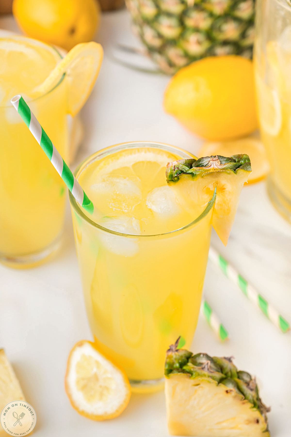 Glass of pineapple lemonade with a pineapple wedge garnish on rim.