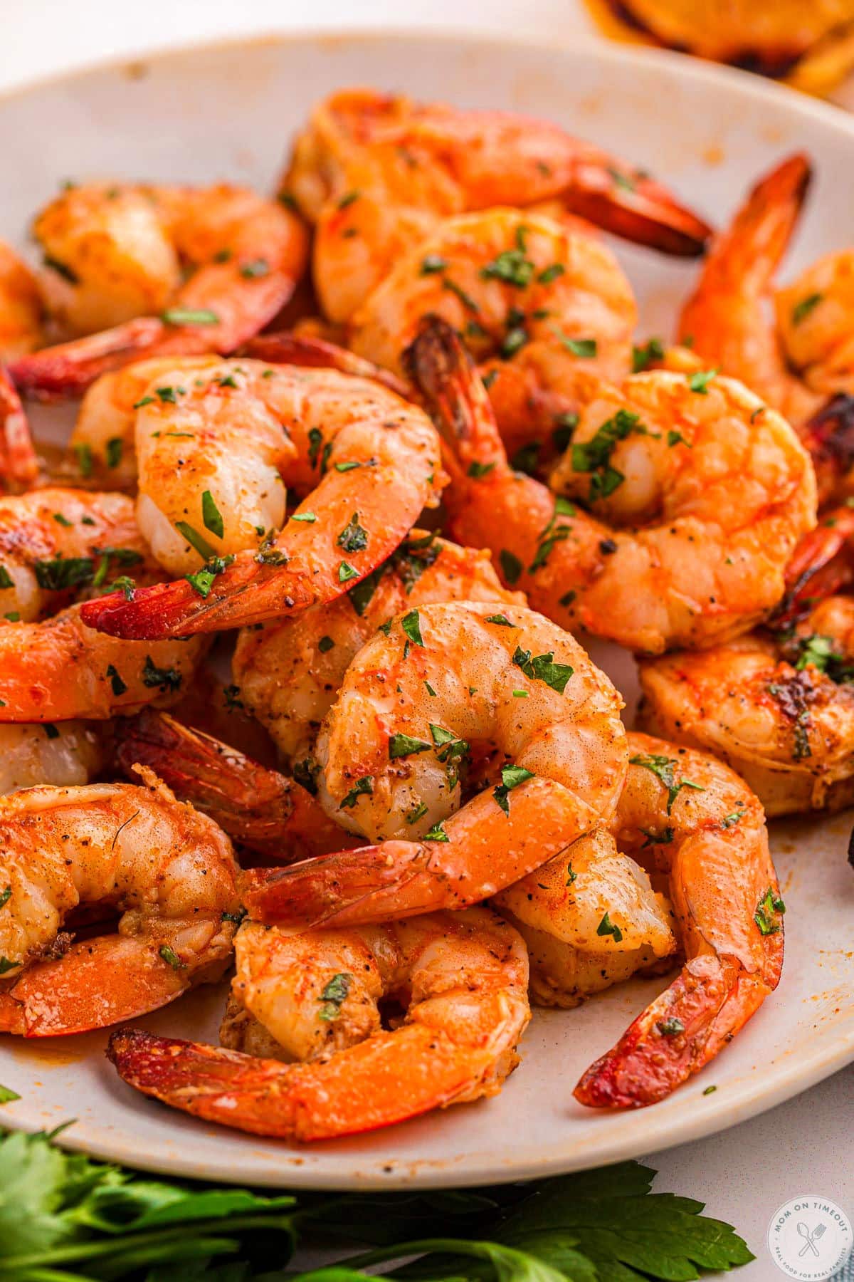 Close up of white dinner plate piled high with cajun shrimp.