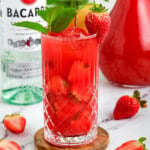 Strawberry Mojito with a bottle of rum in the background.