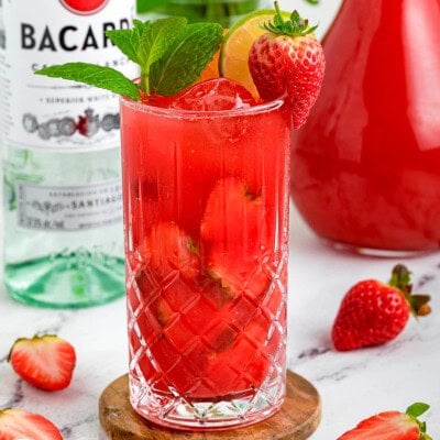 Strawberry Mojito with a bottle of rum in the background.
