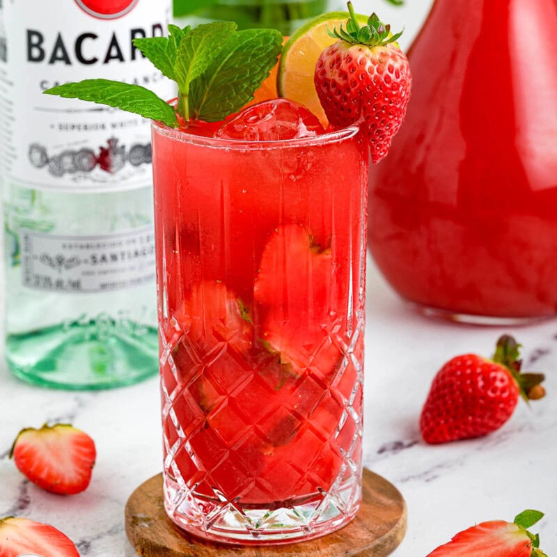 Strawberry Mojito with a bottle of rum in the background.