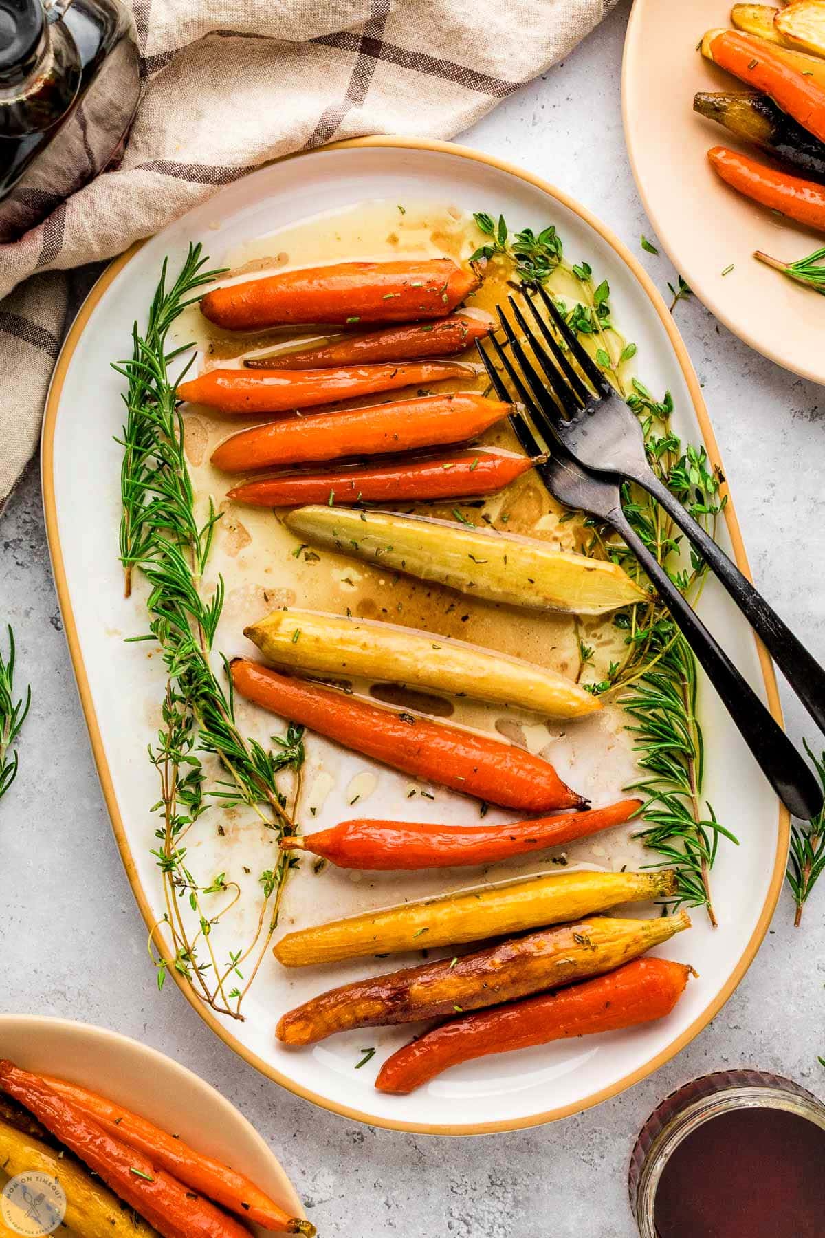 Overhead view of large oval platter with maple glazed carrots on it.