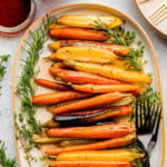 Overhead view of large oval platted with maple glazed carrots on it.