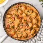 Marry me chicken meatballs in skillet with creamy sun dried tomato and Parmesan sauce. Mashed potatoes in bowl to the side.