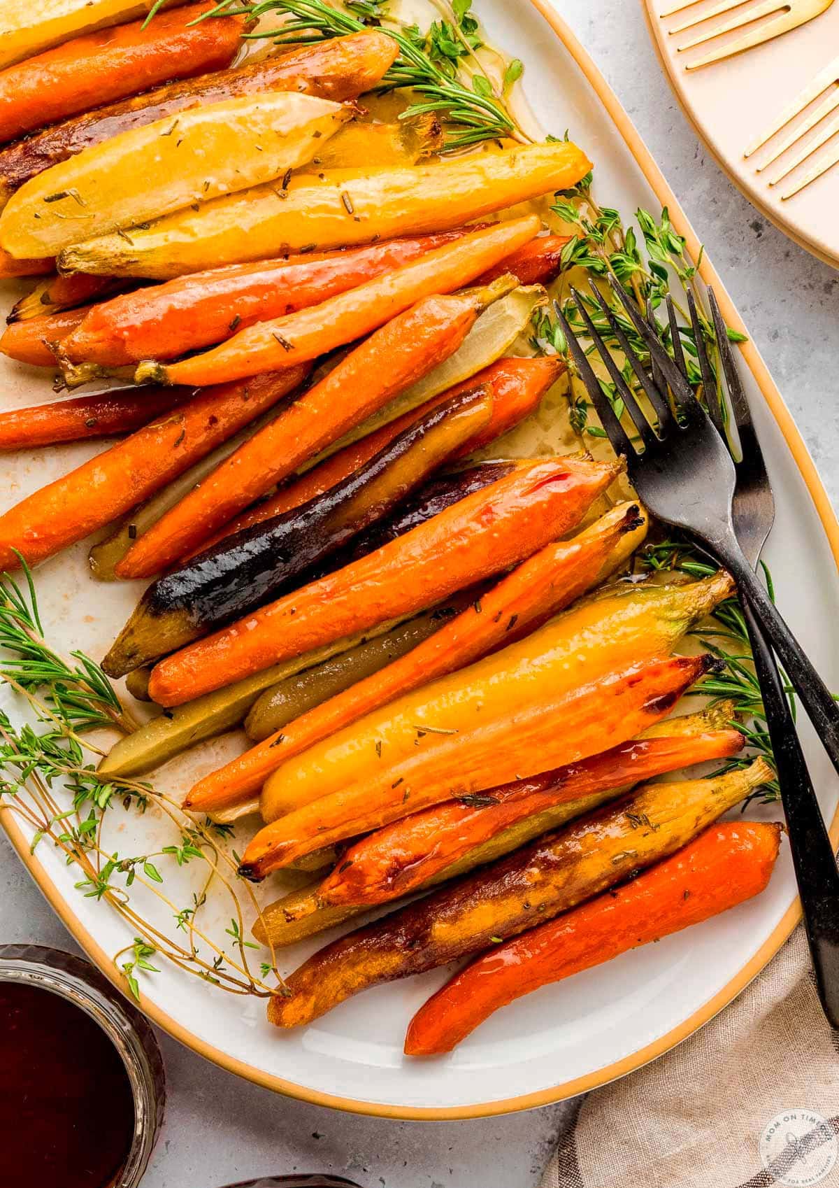 Overhead close up view of large oval platted with maple glazed carrots on it.