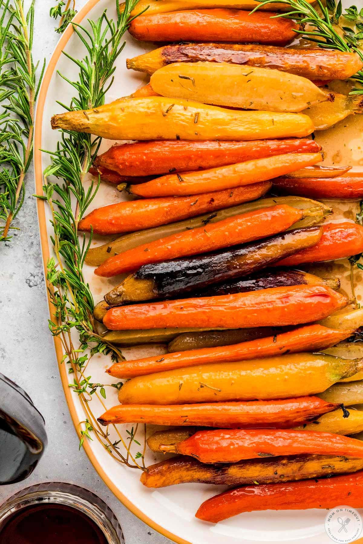 Overhead close up view of large oval platter with maple glazed carrots on it.